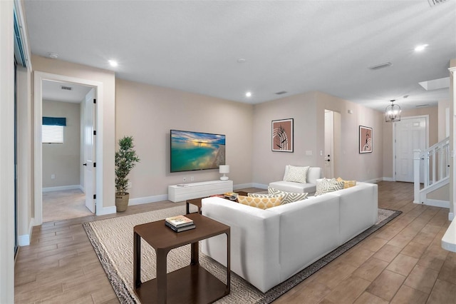 living room with recessed lighting, baseboards, visible vents, and light wood finished floors