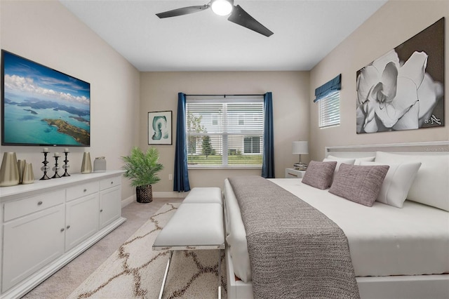 bedroom with ceiling fan and light colored carpet