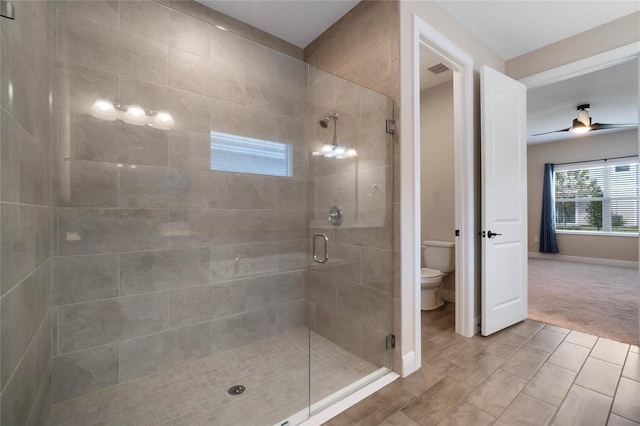 bathroom with wood-type flooring, toilet, walk in shower, and ceiling fan