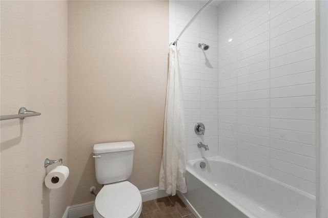 bathroom featuring wood tiled floor, baseboards, shower / bathtub combination with curtain, and toilet