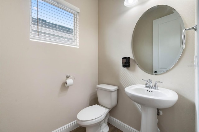 bathroom with baseboards and toilet