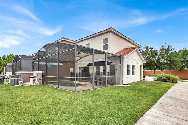 back of house featuring a patio, a lanai, a pool with hot tub, central AC unit, and a yard