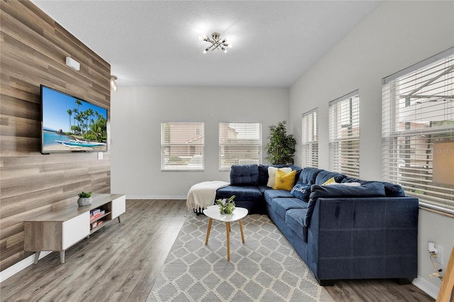 living room featuring wood walls, a healthy amount of sunlight, and wood-type flooring