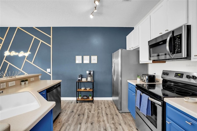 kitchen with white cabinets, appliances with stainless steel finishes, light hardwood / wood-style flooring, and blue cabinets