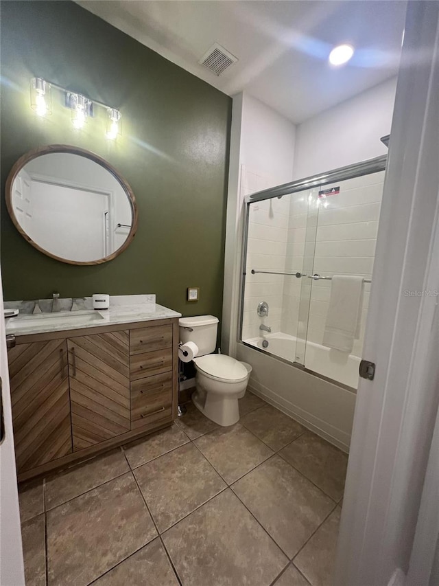 full bathroom with tile patterned floors, vanity, enclosed tub / shower combo, and toilet