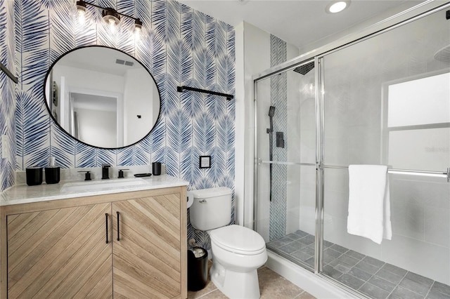 bathroom featuring tile patterned floors, vanity, toilet, and a shower with door