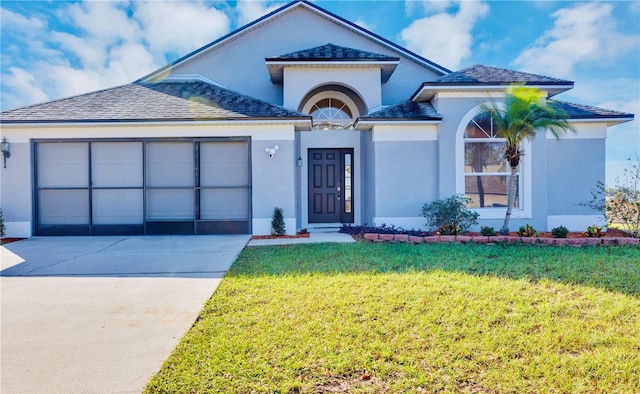 view of front of home with a front yard and a garage