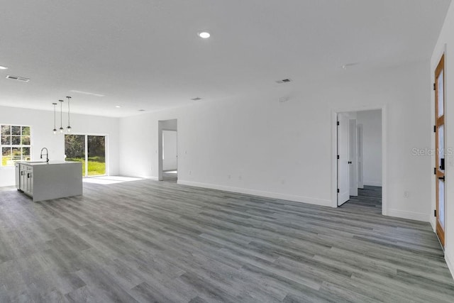 unfurnished living room with sink and light wood-type flooring