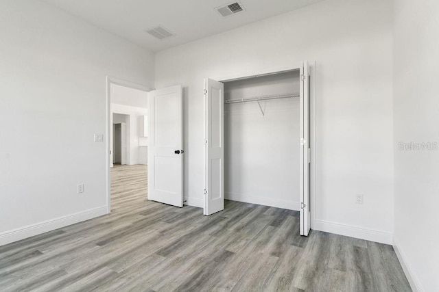 unfurnished bedroom featuring light hardwood / wood-style floors and a closet