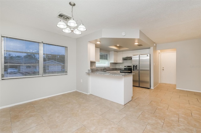 kitchen with appliances with stainless steel finishes, kitchen peninsula, pendant lighting, white cabinets, and light stone counters