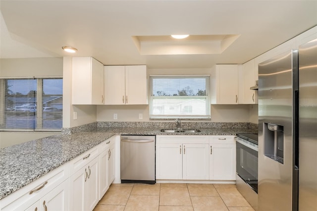 kitchen featuring white cabinetry, a raised ceiling, appliances with stainless steel finishes, and a sink