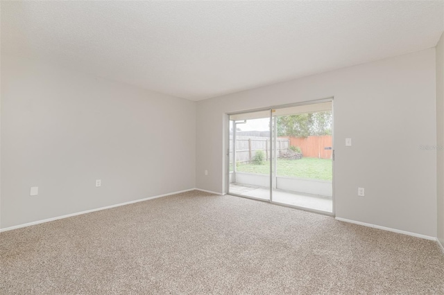 spare room featuring carpet floors and baseboards