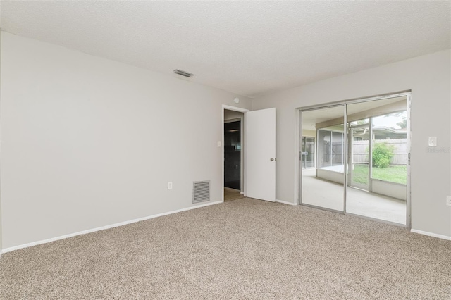 unfurnished room with carpet and a textured ceiling