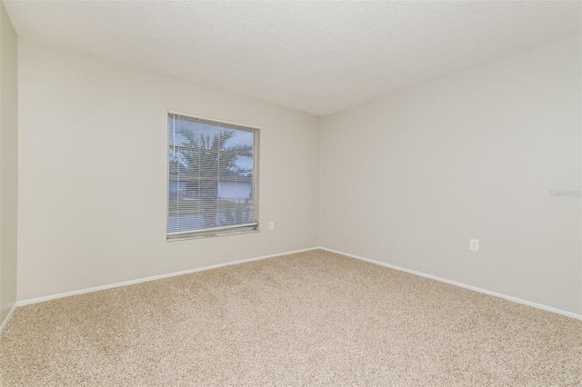 carpeted spare room with a textured ceiling