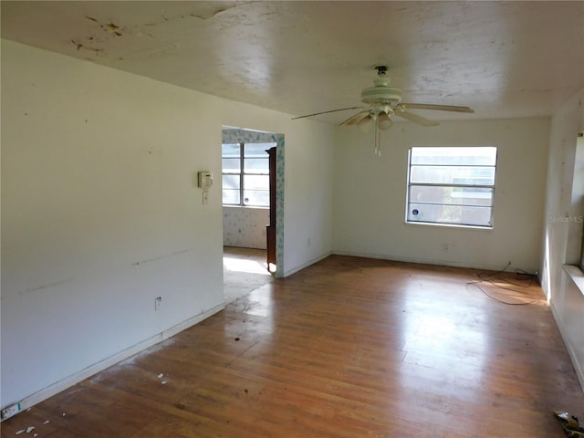 unfurnished room with ceiling fan and hardwood / wood-style flooring