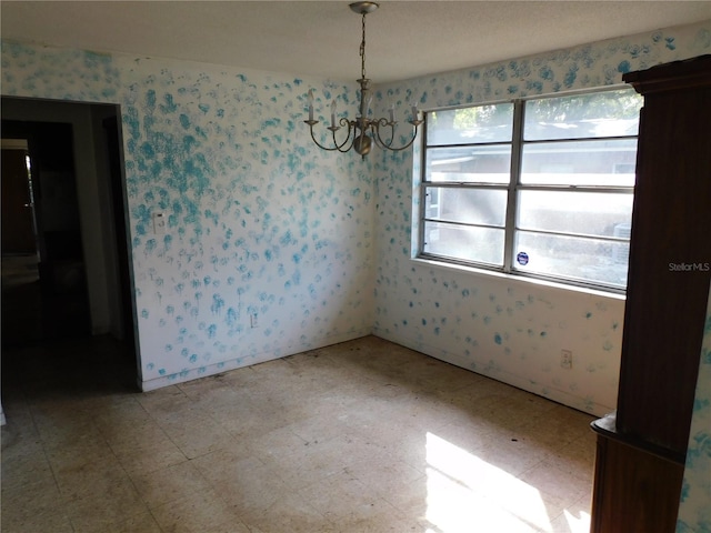 unfurnished dining area featuring a chandelier