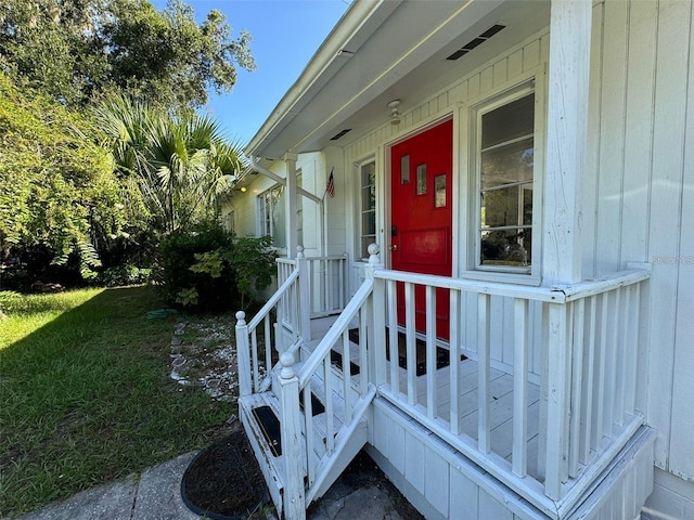 view of exterior entry with a yard