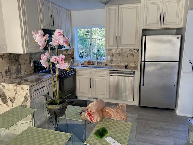 kitchen with sink, decorative backsplash, stainless steel appliances, and light hardwood / wood-style floors