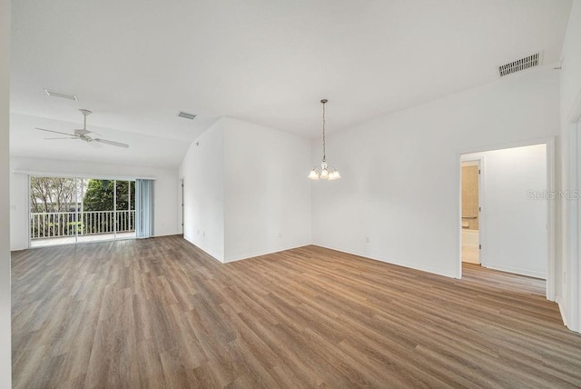 unfurnished room with light hardwood / wood-style flooring, ceiling fan with notable chandelier, and vaulted ceiling