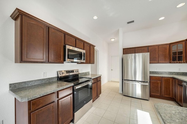 kitchen featuring dark brown cabinets, stainless steel appliances, and light tile patterned floors