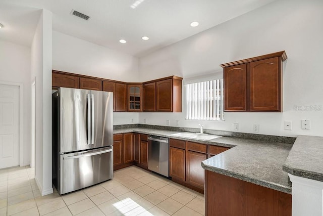 kitchen featuring appliances with stainless steel finishes, kitchen peninsula, sink, and light tile patterned flooring