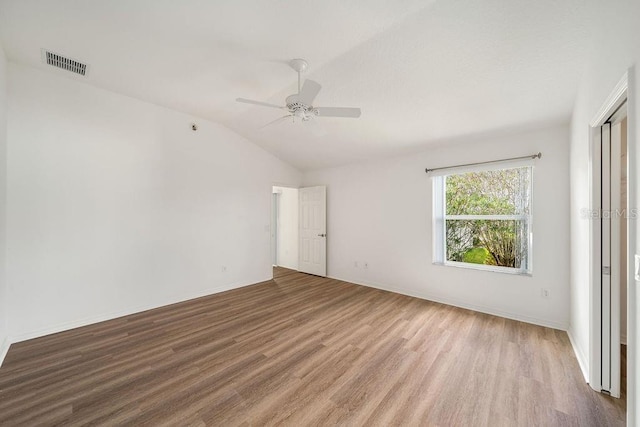 spare room with vaulted ceiling, light hardwood / wood-style flooring, and ceiling fan