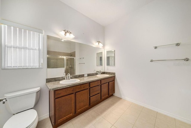 bathroom featuring a shower with door, vanity, toilet, and tile patterned floors