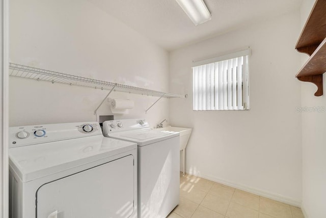 laundry area featuring washer and dryer and light tile patterned floors