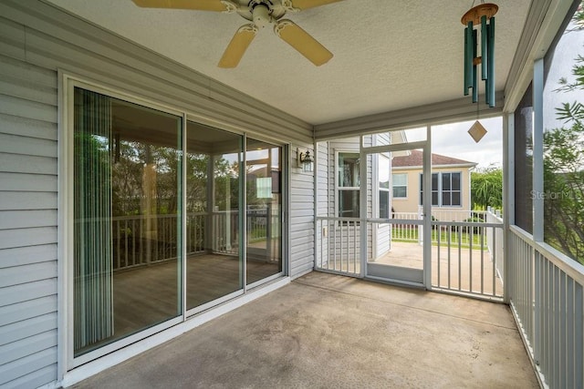 unfurnished sunroom featuring ceiling fan and a wealth of natural light