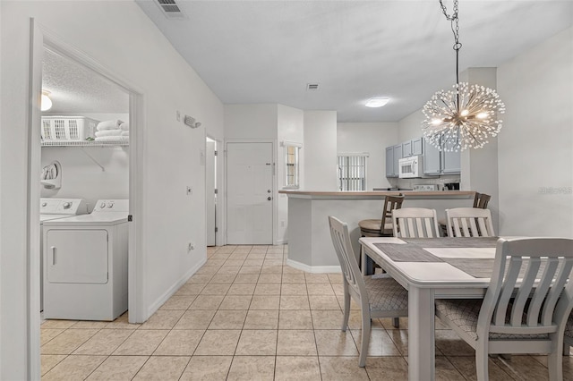1029 Park Ridge Cir, Kissimmee, FL 34746 - dining area featuring washing machine and clothes dryer, a chandelier, light tile patterned flooring, and baseboards