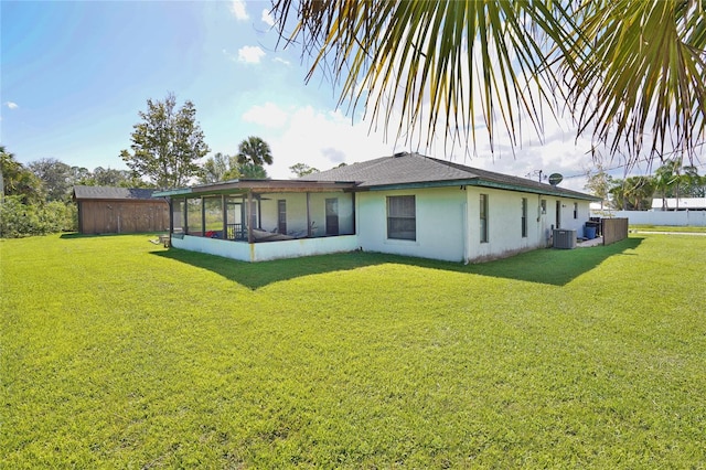 back of property with a yard, a sunroom, and central air condition unit