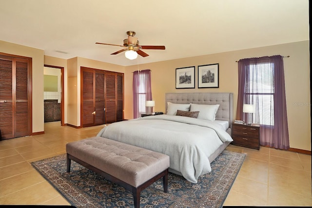 bedroom with ceiling fan, multiple closets, and light tile patterned flooring