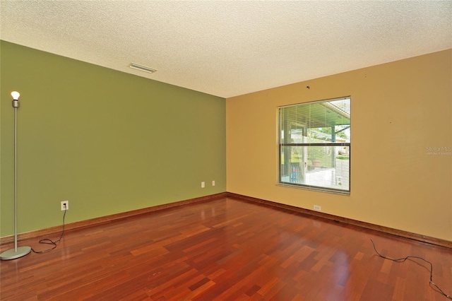 empty room featuring a textured ceiling and wood-type flooring