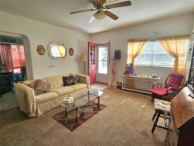 carpeted living room with a textured ceiling and ceiling fan