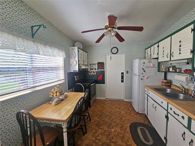 kitchen featuring sink, dark parquet flooring, white cabinetry, vaulted ceiling, and white refrigerator