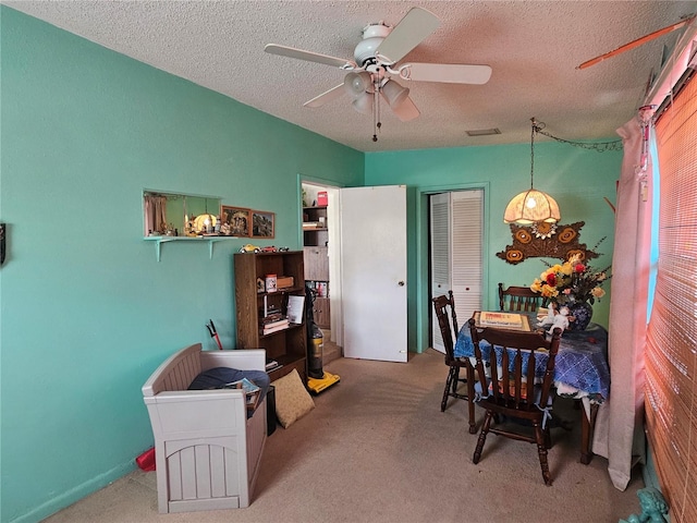 dining room with carpet floors, a textured ceiling, and ceiling fan