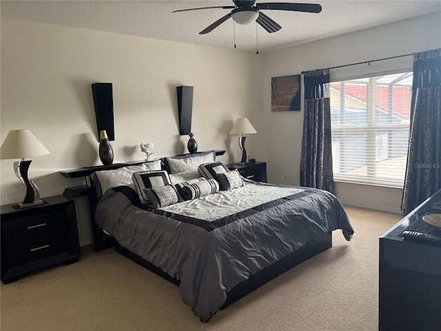 bedroom with a textured ceiling, a ceiling fan, and light carpet
