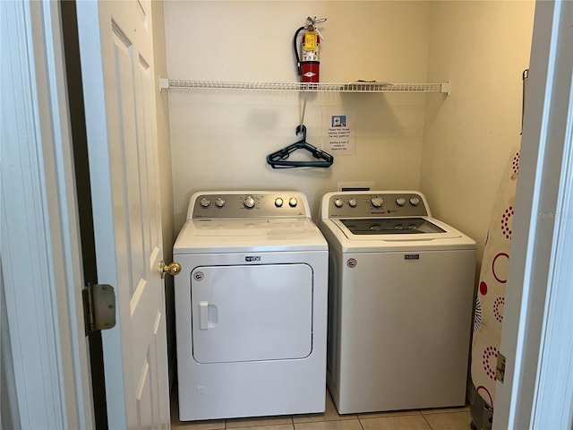 laundry room with light tile patterned flooring, laundry area, and washer and clothes dryer