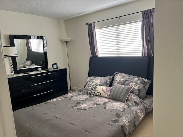 bedroom with a textured ceiling and multiple windows