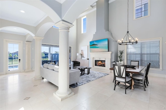 tiled living room with a chandelier, crown molding, and a high ceiling