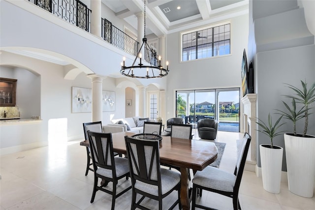 dining room featuring coffered ceiling, beam ceiling, decorative columns, a chandelier, and a towering ceiling