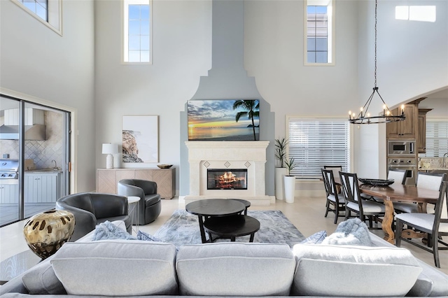 living room with sink, a notable chandelier, and a towering ceiling