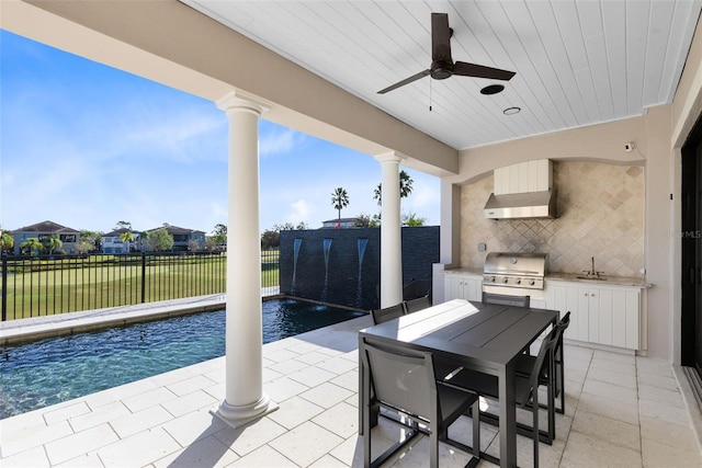 view of patio with exterior kitchen, ceiling fan, pool water feature, a fenced in pool, and a grill