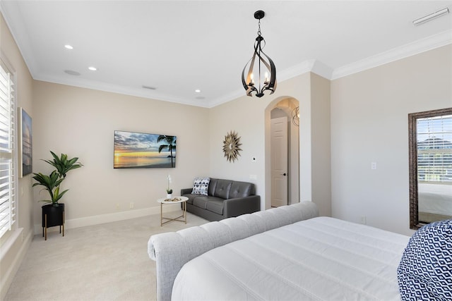 carpeted bedroom with ornamental molding and a chandelier