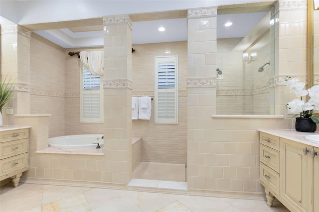 bathroom featuring vanity, tile walls, and independent shower and bath