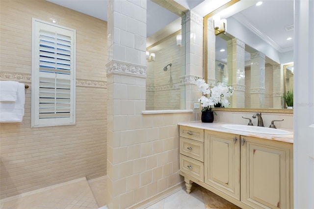 bathroom featuring tile walls, tiled shower, vanity, crown molding, and tile patterned floors