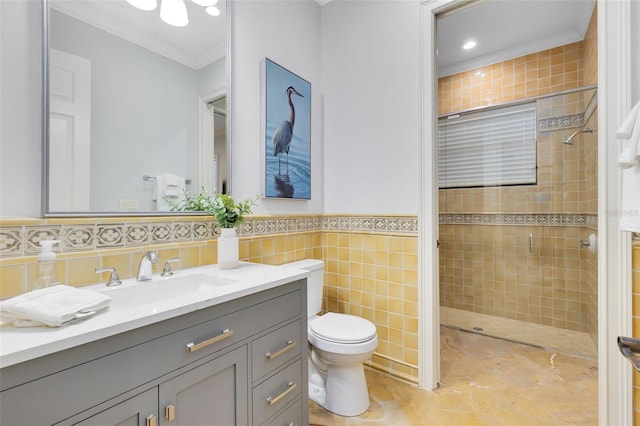 bathroom featuring tile walls, toilet, ornamental molding, tiled shower, and vanity