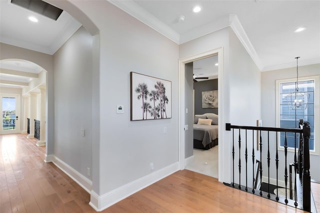 hallway featuring ornamental molding, a notable chandelier, and hardwood / wood-style floors