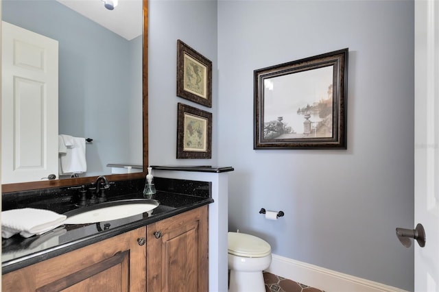 bathroom with toilet, vanity, and tile patterned floors