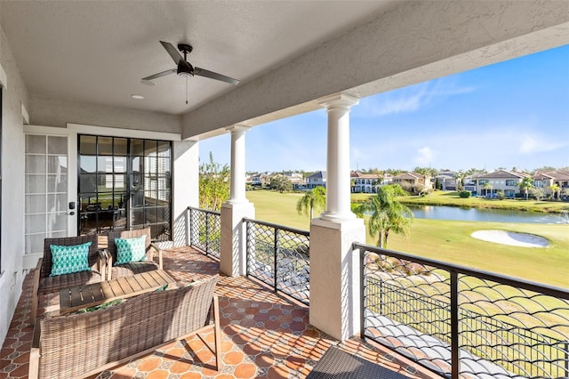 balcony featuring a water view and ceiling fan